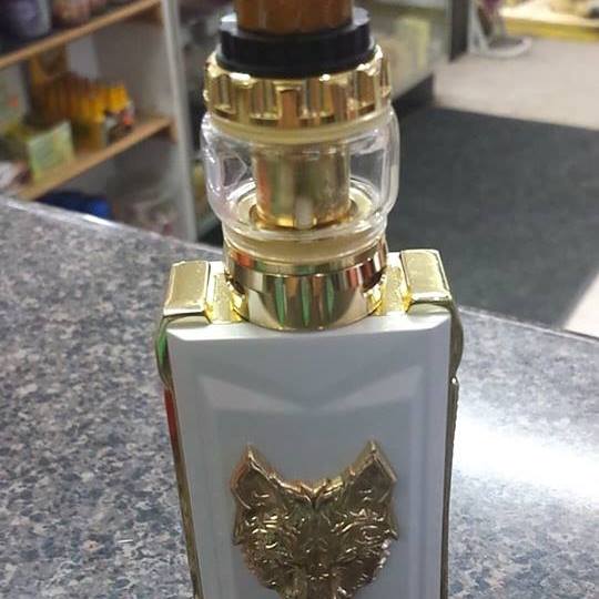 Stylish white and gold vape device with a lion emblem, placed on a countertop.